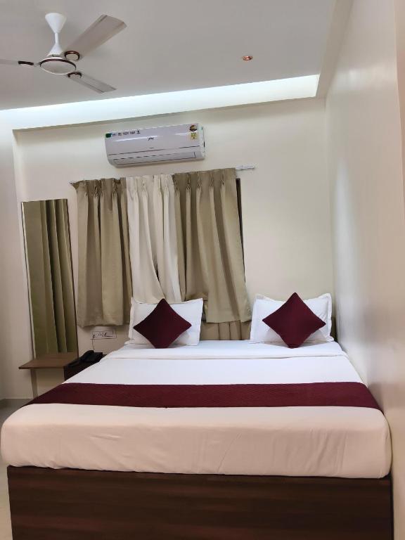a bedroom with a large bed with a window at Hotel Atithi Lodging Pune in Pune