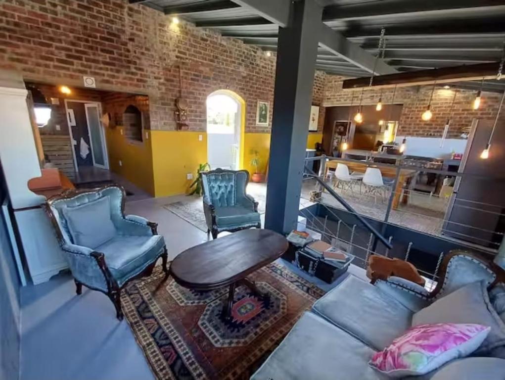 a living room with chairs and a couch and a table at Luxurious and spacious 2 level apartment in Tygerberg Hills
