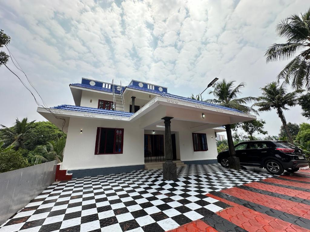 a house with a car parked in front of it at Richards Shared Apartment-AC in Thiruvalla