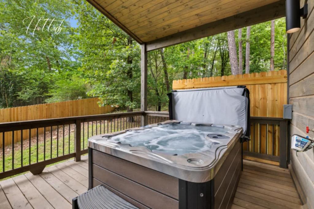 a hot tub on the deck of a house at Escape to Tranquility - Hot Tub - BBQ - Pets in Broken Bow