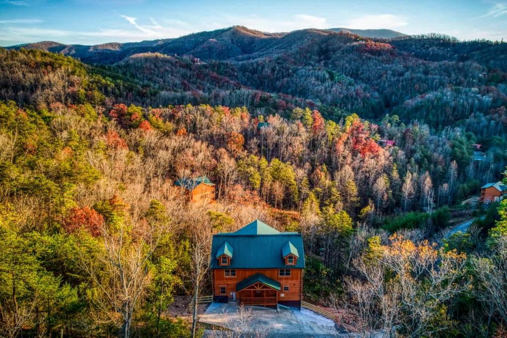 an autumn view of a cabin in the forest at Paradise Pointe Pool Lodge by Beyond Expectations in Sevierville