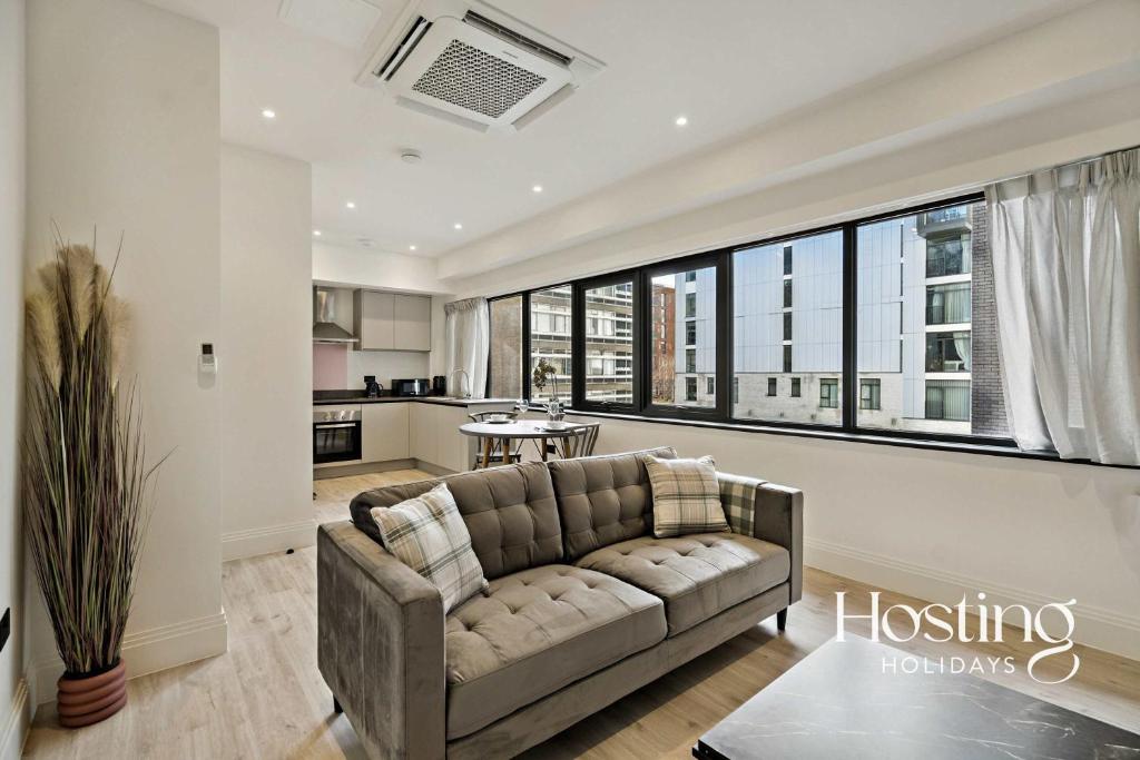 a living room with a couch and a large window at Platform One Apartments - Caversham in Reading
