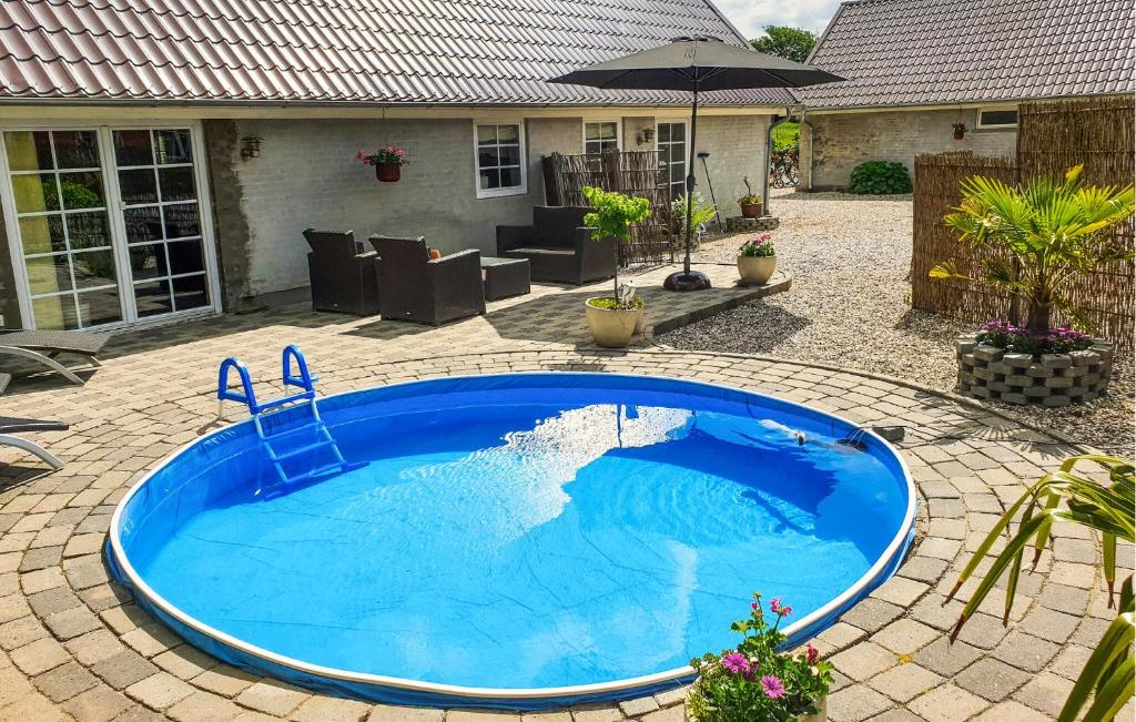 a large blue swimming pool in a yard at Apartment Sønderskovhedevej in Langå