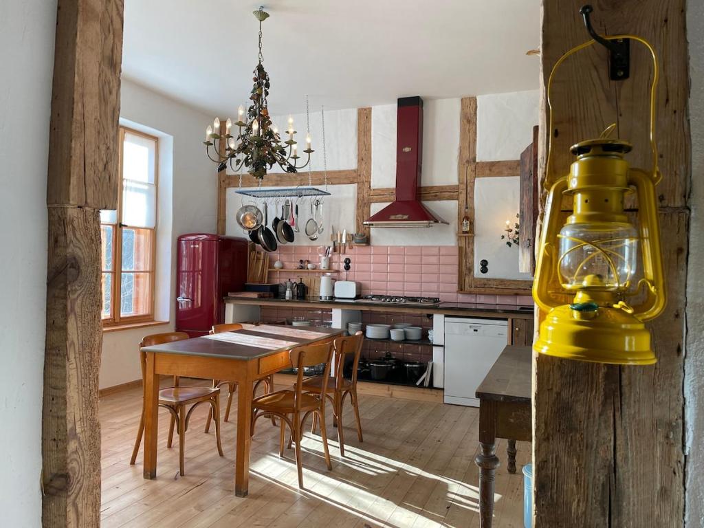 a kitchen with a wooden table and a yellow light at Die Orchidee - Gutshaus Bückling in Rambin