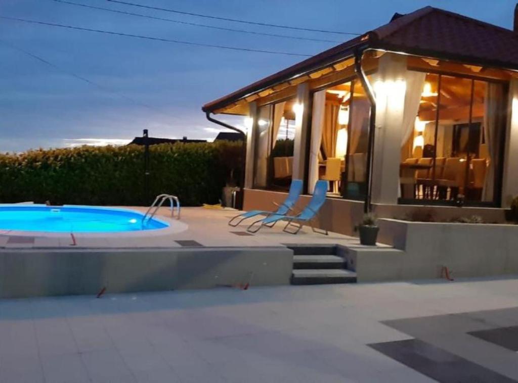 a house with a swimming pool next to a building at Belajec Wine & Nature Retreat in Veliko Brdo