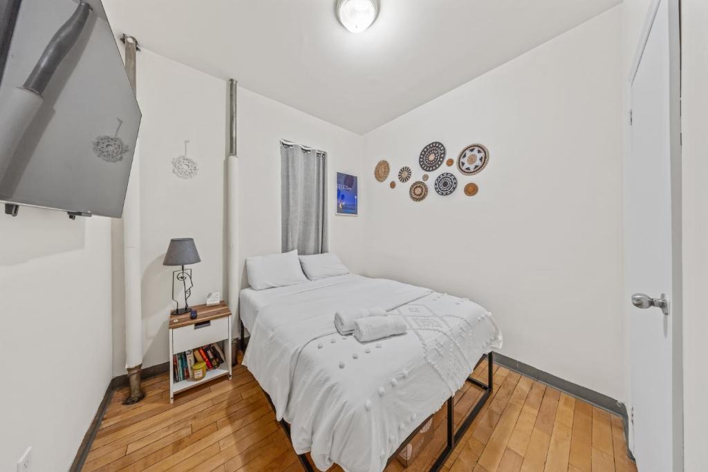 a white bedroom with a bed and a window at Chic Times Square 1-Bedroom Apartment - Hosts 4 in New York
