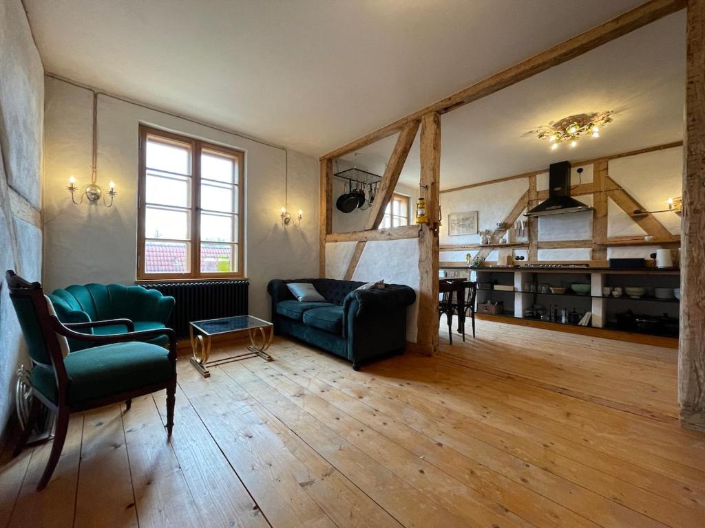 a living room with a couch and a table at Die Perle - Gutshaus Bückling in Rambin