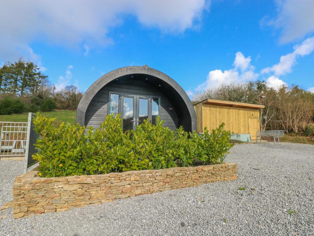 a circular house with a window in a garden at Thelmas Lodge in Llanelli