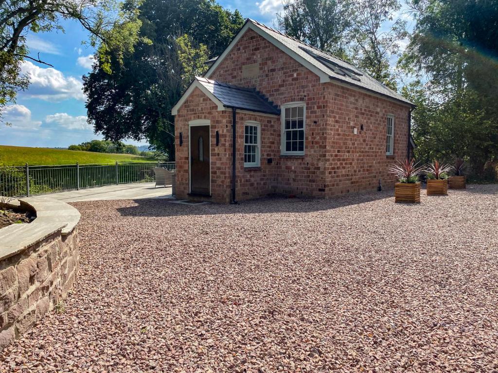 a brick building on a gravel driveway at Broadmoor Chapel in Hereford