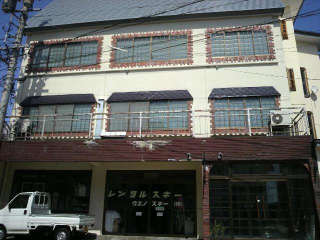 a white truck parked in front of a building at Lodge Ueno Ski in Nozawa Onsen