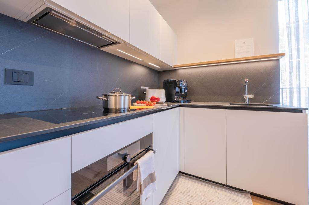 a kitchen with white cabinets and a sink at Appartament Seceda in San Sigismondo