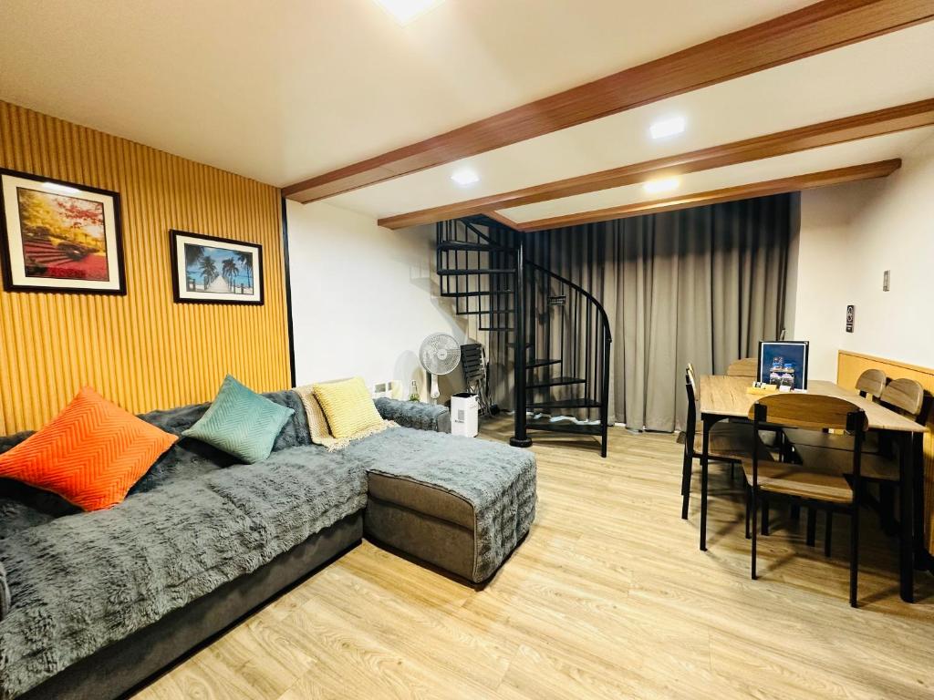 a living room with a bed and a dining room at Loft2600 in Baguio