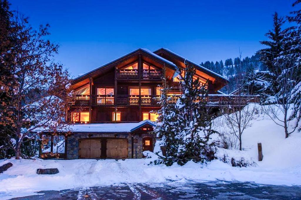 a large log cabin in the winter with snow at Chalet Les Solans in Les Allues
