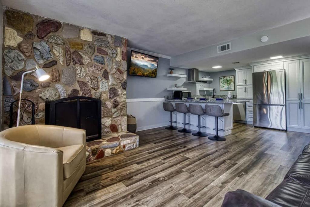 a living room with a fireplace and a stone wall at 1023 English Mtn Condo by Beyond Expectations in Sevierville