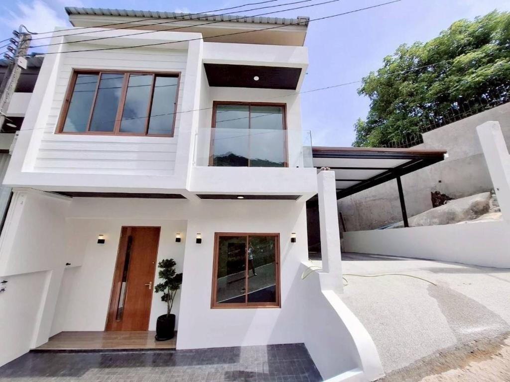 a house with white walls and windows at Patong Relax Home in Patong Beach
