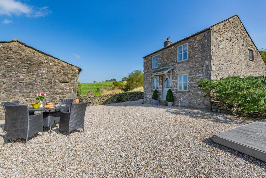 a stone house with a table and chairs in front of it at 2 Bed in Middleton oc-m29515 in Middleton