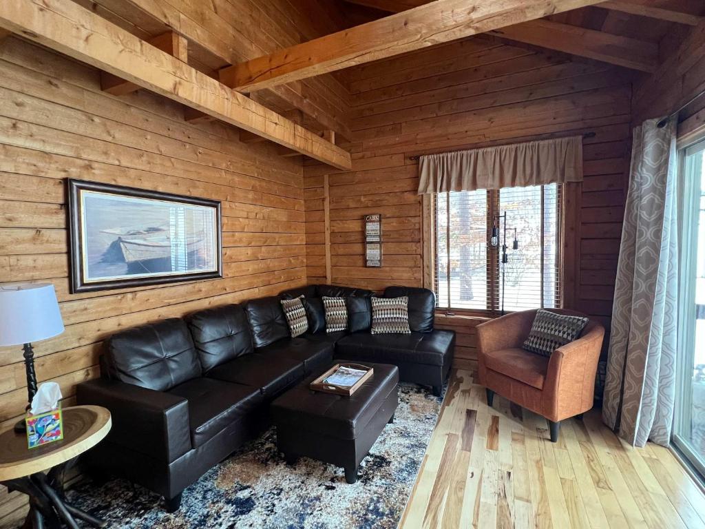 a living room with a black leather couch and a chair at Private Cabin-Shuttle Pass Included! in Thompsonville