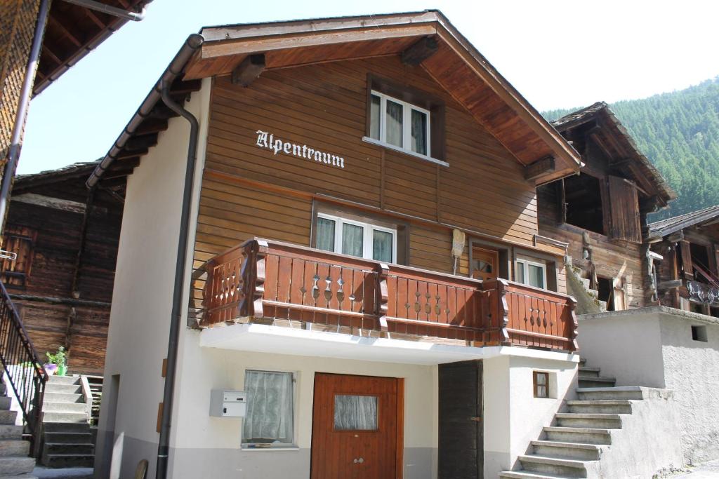 ザース・グルントにあるChalet Alpentraum, alte Gasse 20の木造の家屋で、バルコニーが付いています。