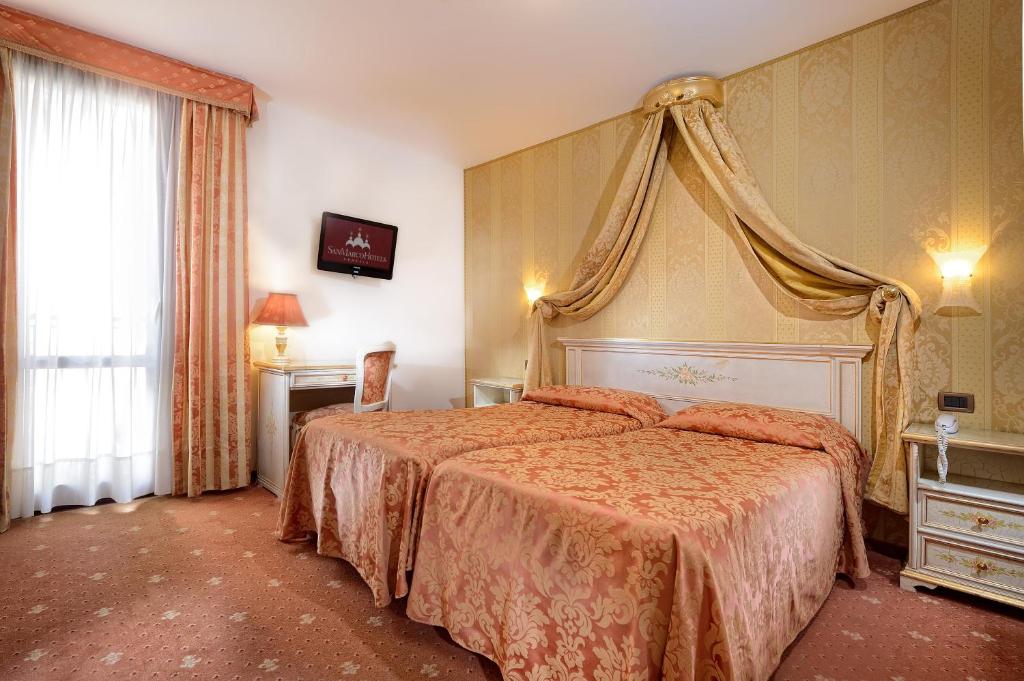 威尼斯的住宿－泰利羅莎大使酒店，一间卧室配有一张带天蓬的大床