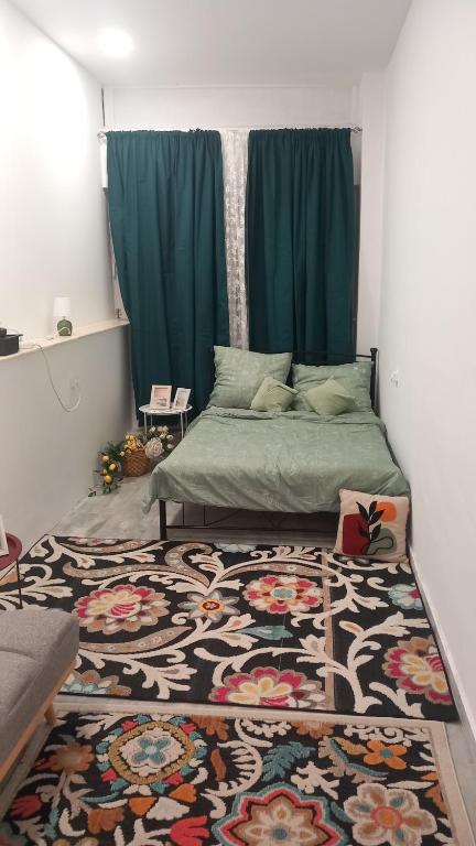 a bedroom with a bed with a rug and blue curtains at House Marios airport 3 in Spata