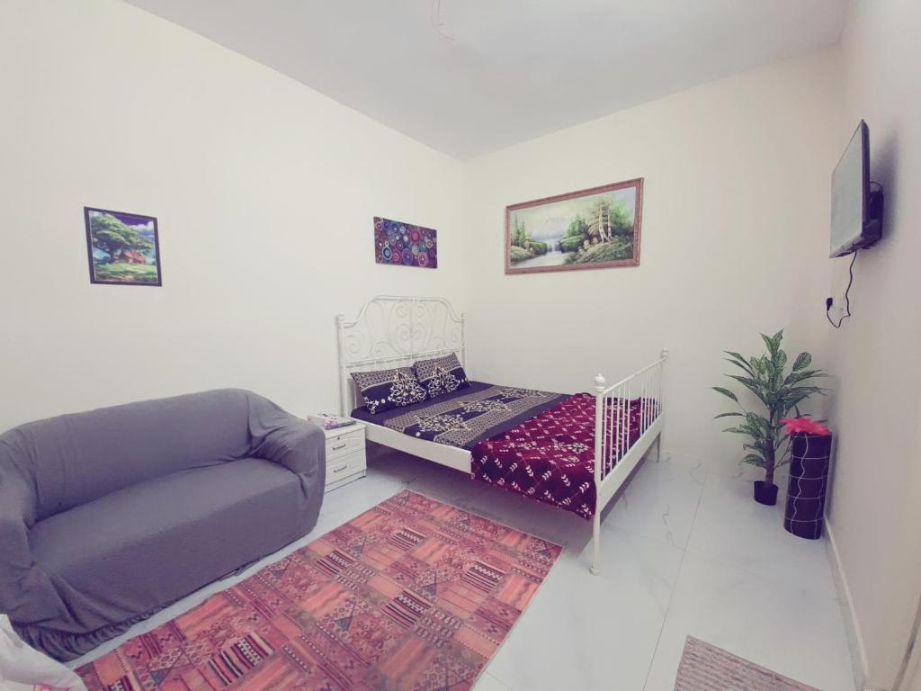 a small living room with a bed and a couch at Friendlyhomes in Al Ain
