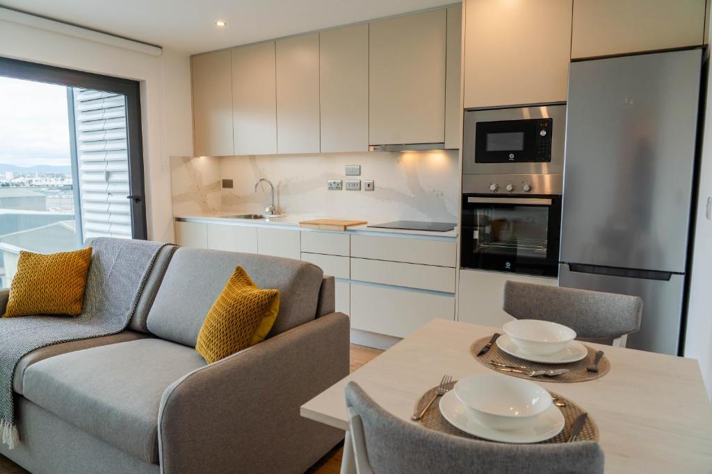 a kitchen and living room with a couch and a table at Victory Suites in Gibraltar