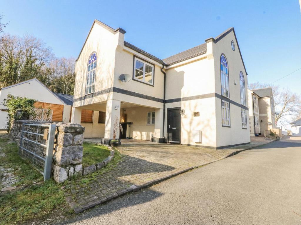 a large white house with a driveway at Capel Y Ffynnon in Llandudno Junction