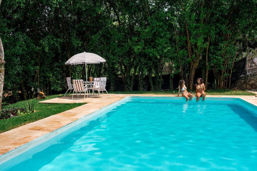 two girls are playing in a swimming pool at Gardin Home in Cali