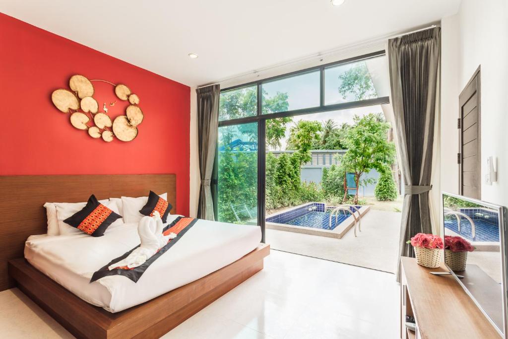 ein Schlafzimmer mit einer roten Wand, einem Bett und einem großen Fenster in der Unterkunft Boutique Pool Villa in Mae Nam