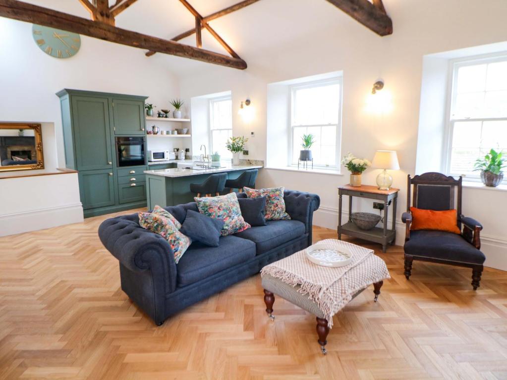 a living room with a blue couch and a table at The Reading Room in Grindleford Bridge