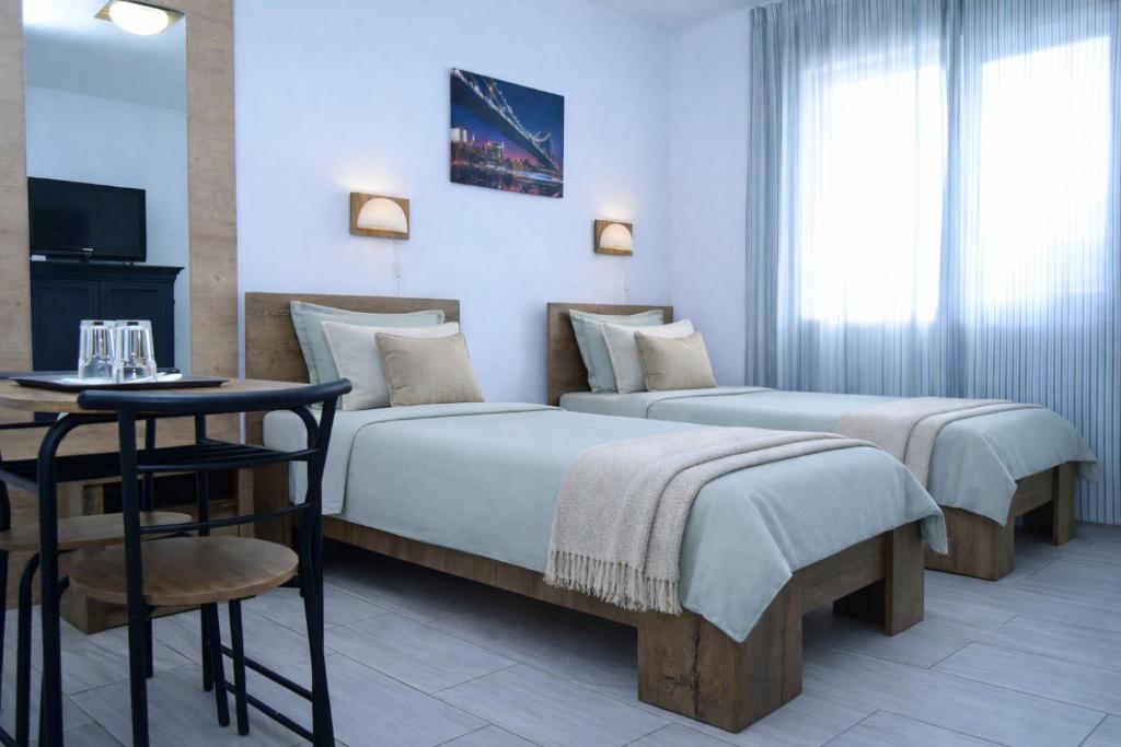 a hotel room with two beds and a table and a television at Hotel Road Rooms in Voluntari