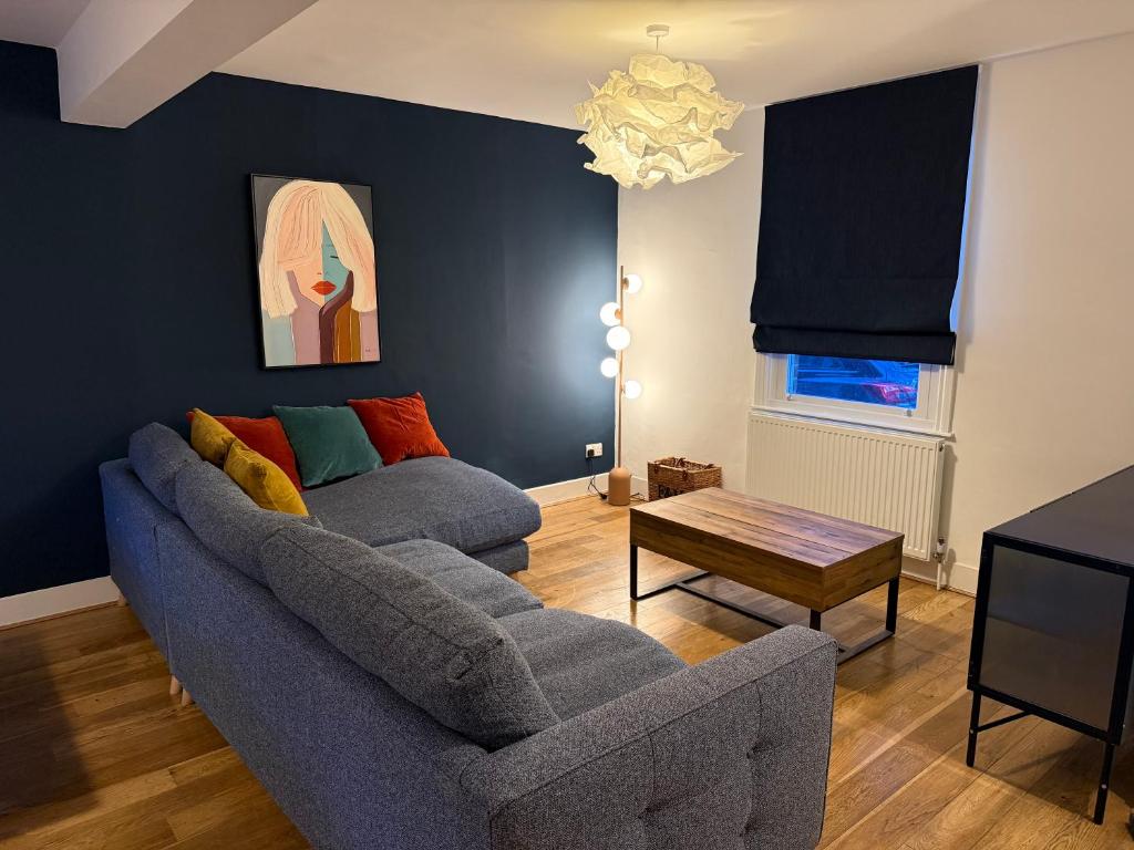a living room with a couch and a table at 5 Bed Cottage in Enfield