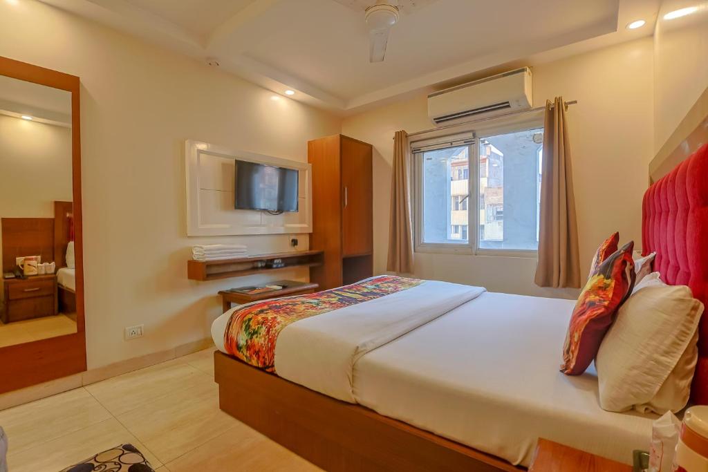 a hotel room with a bed and a television at Avtar new delhi railway station in New Delhi