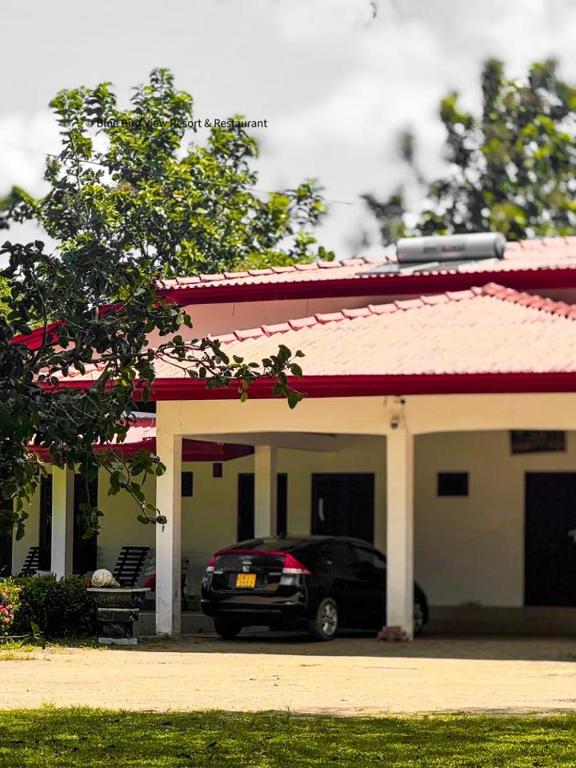a car parked in front of a house at Forest Edge Yala Resort in Gotamegama