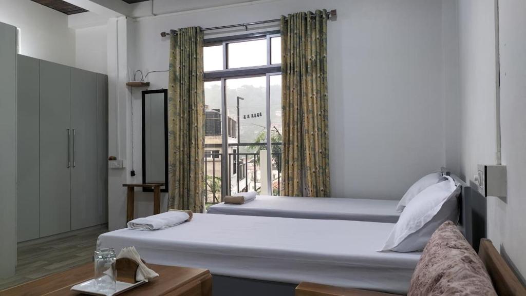 a bedroom with a large bed and a window at Zosang Homestay in Āīzawl