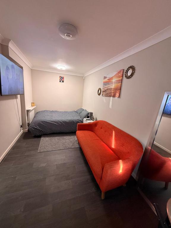 a bedroom with a red couch and a bed at Demure Living Space in Southampton