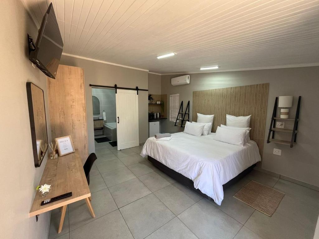 a bedroom with a large white bed and a television at Stay at Tzaneen in Tzaneen
