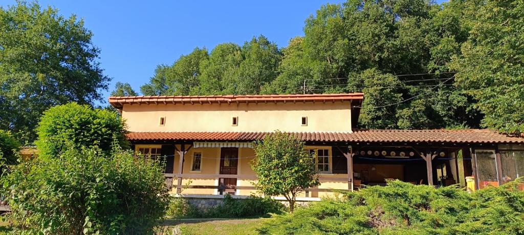 a large house with trees in the background at Le Village Champignon in Aspet