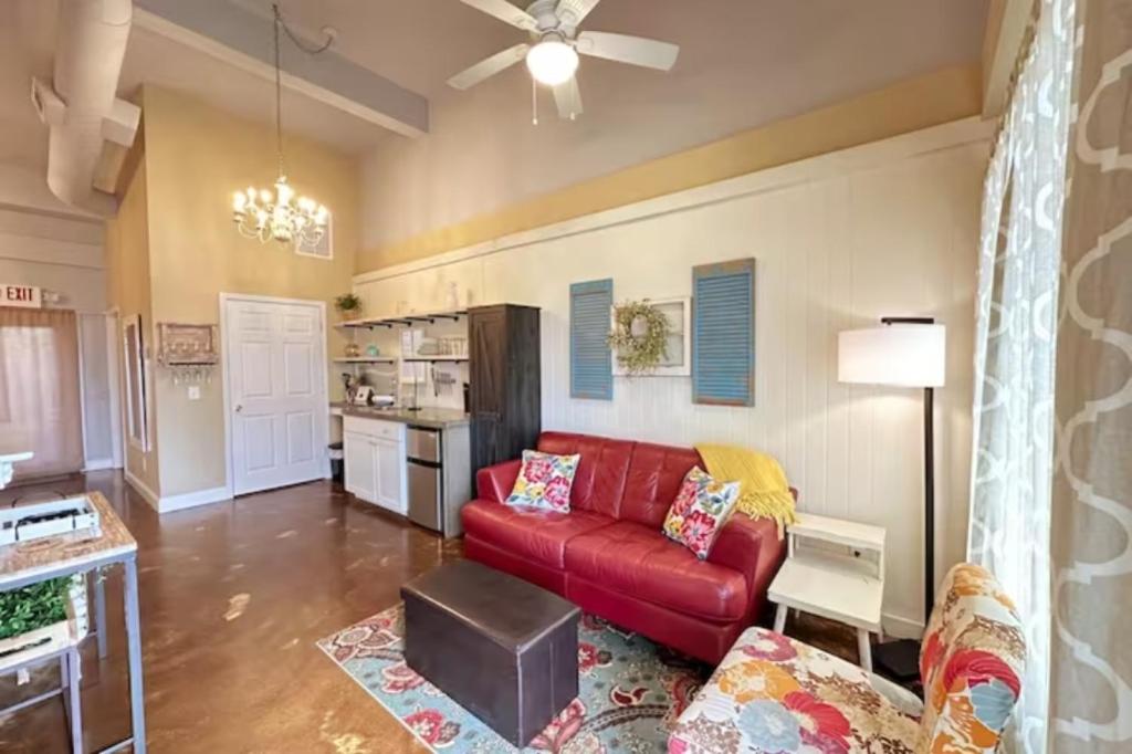 a living room with a red couch and a kitchen at Haven at Hazel~Downtown Bungalow in Demorest