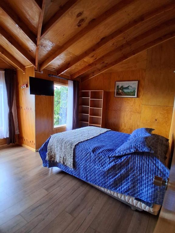 a bedroom with a bed in a room with wooden ceilings at Cabañas Canaan in Coñao