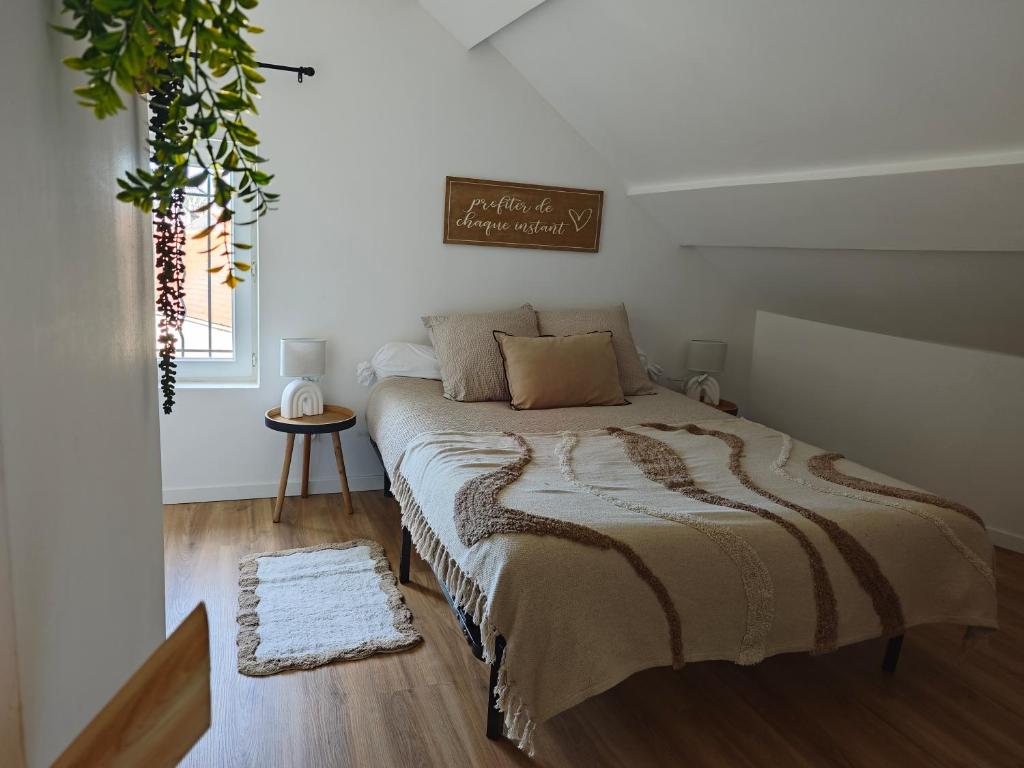 a bedroom with a bed in a white room at Le Cocon in Sermaises