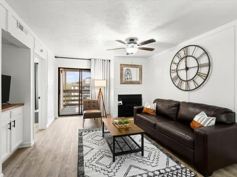 a living room with a couch and a clock on the wall at Turkey Nest by Beyond Expectations Renovated 2BR in Gatlinburg