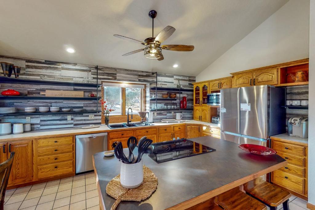 a kitchen with wooden cabinets and stainless steel appliances at Work & Play! Spacious Lake-View Home in Greeley in Greeley