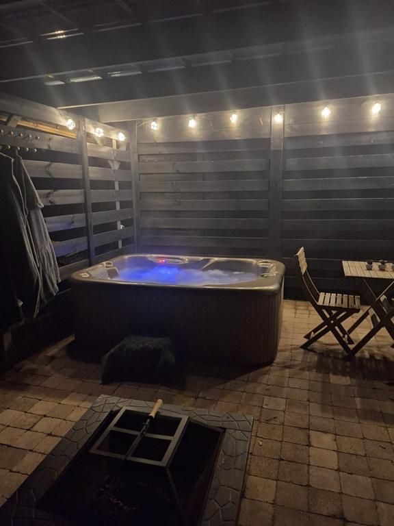a hot tub in a room with a table and a chair at Gîte des binamés in Profondeville