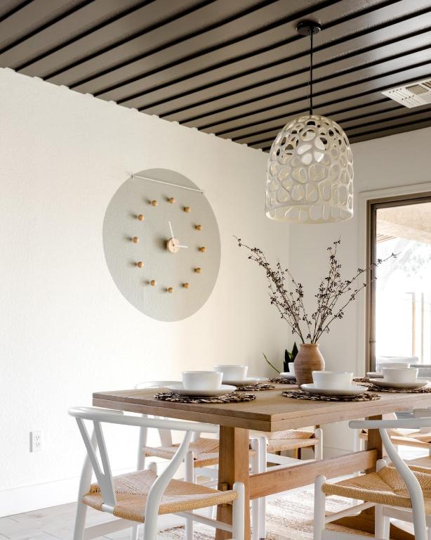 a dining room with a table and a clock on the wall at Copper Cactus House Pool, Spa, Golf! in Queen Creek