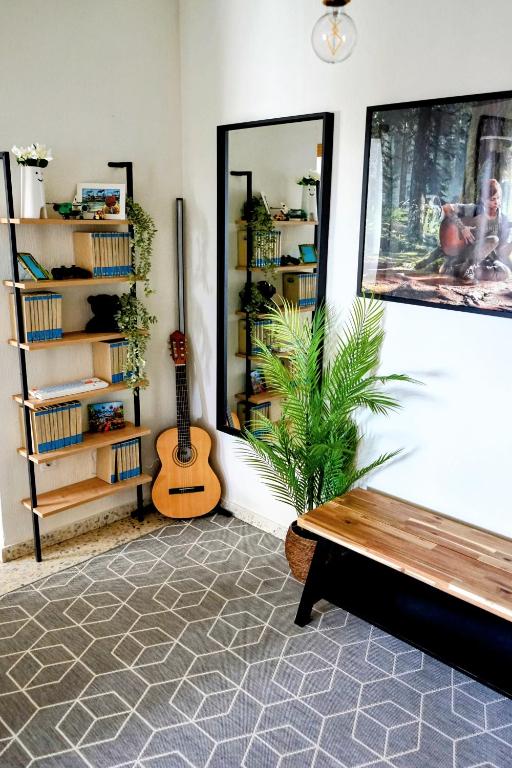 a living room with a bench and a guitar at Casa Belice Huelva in Huelva