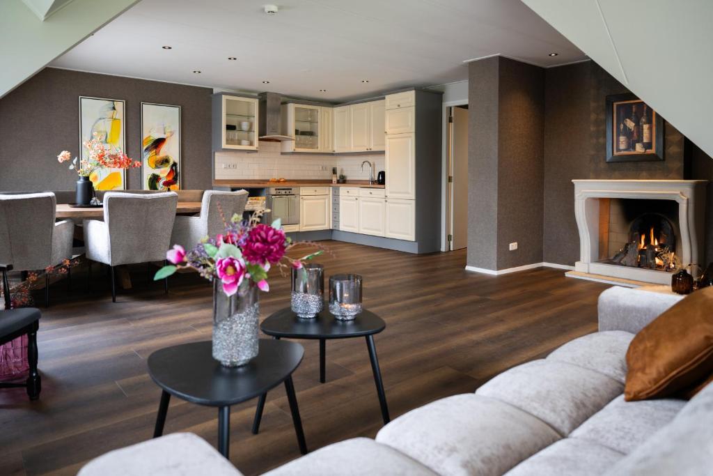a living room with a couch and a table with flowers at Suite Het Koetshuis in Bennekom