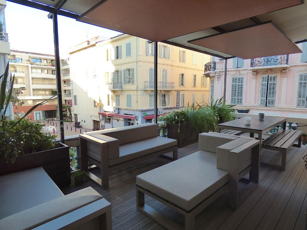 an outdoor patio with tables and chairs and an umbrella at ALC - MOL4 - 8 min Palais in Cannes