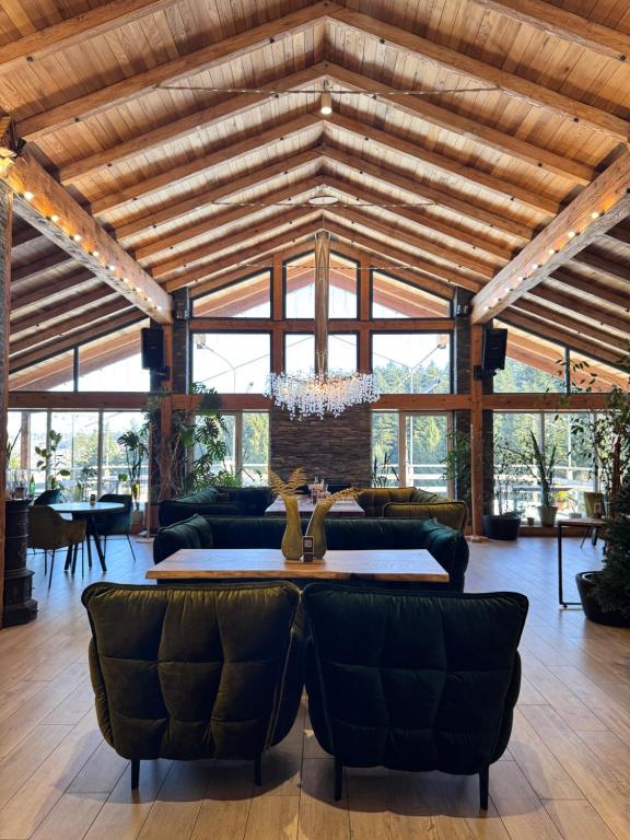 a living room with a wooden ceiling and a chandelier at Парк-готель Щастя in Skhidnitsa
