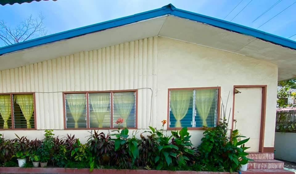 a white house with a blue roof at Tamari's Rest House in Lian